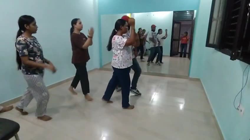 An adults' dance batch mid-class in the academy's hall